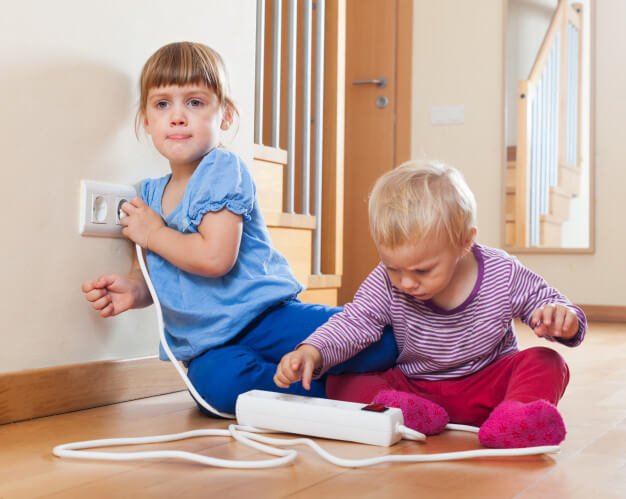 Children playing with electrical extension cord