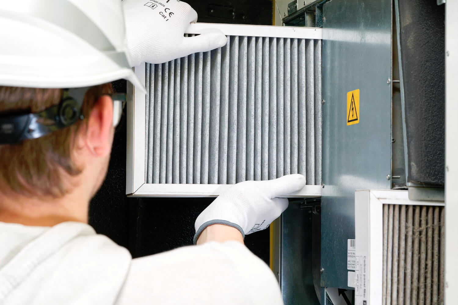 HVAC filter replacement home central air system servicemen changing filter in furnace