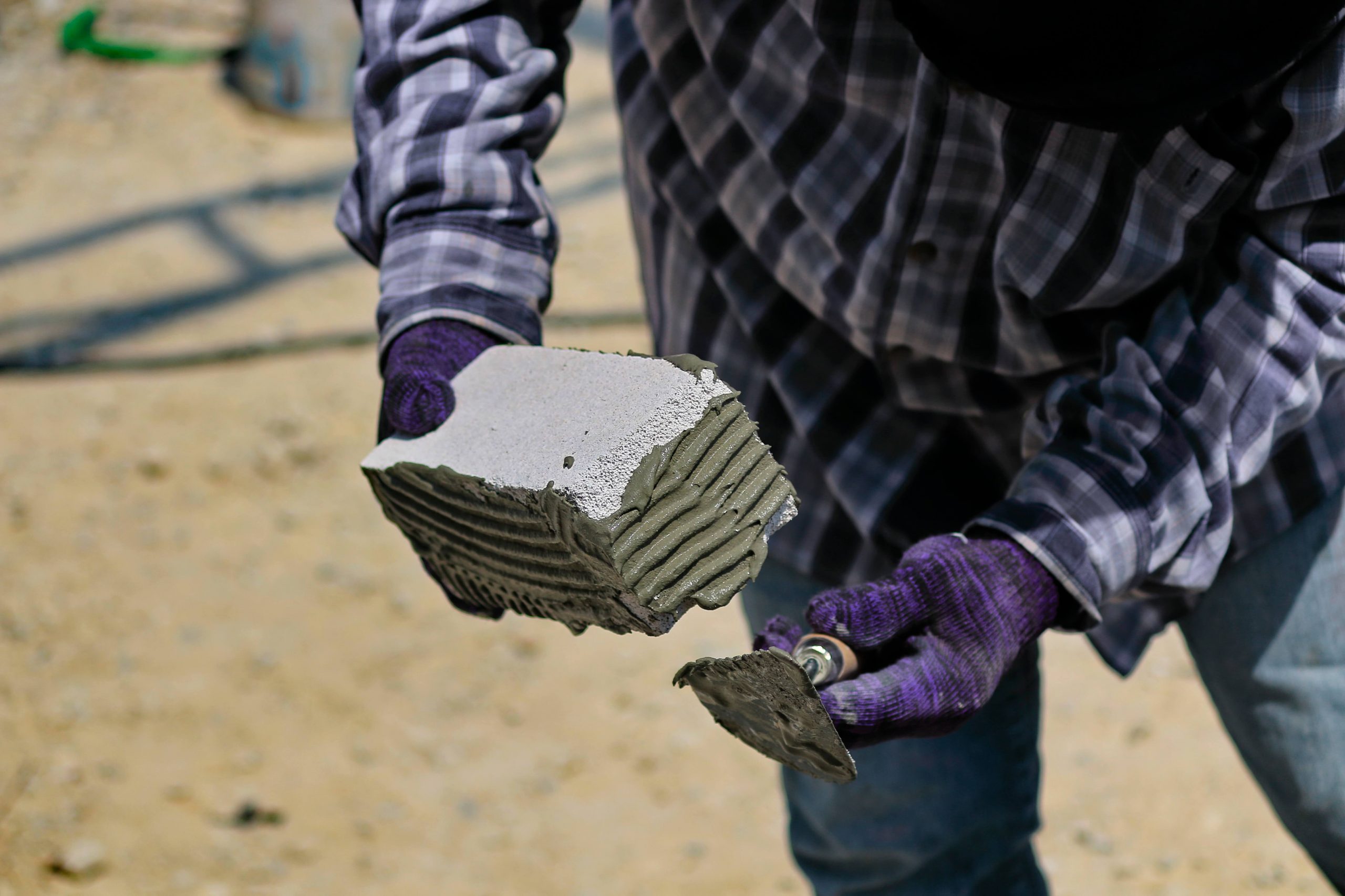 Construction worker with brick with joint compound in