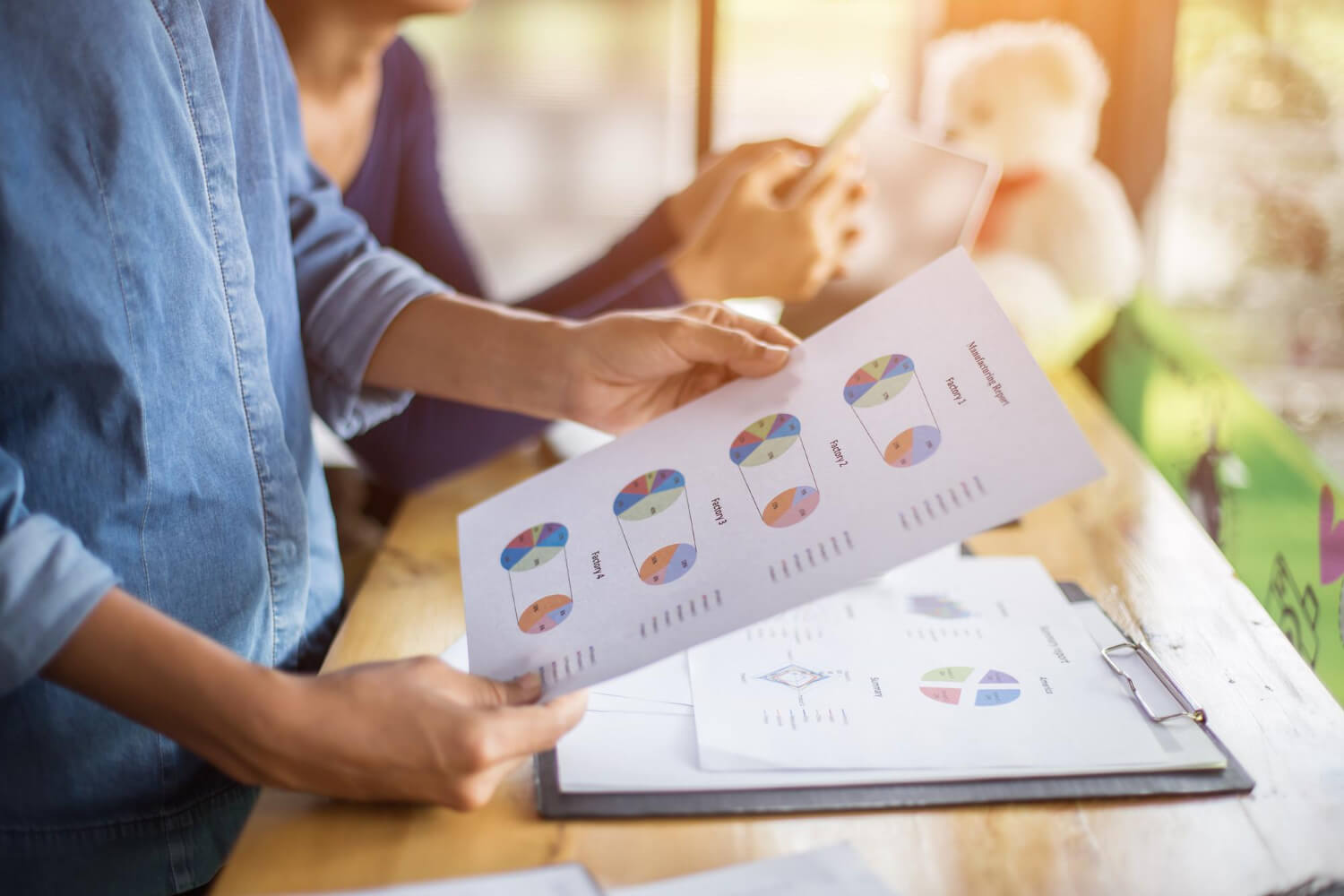 A professional reviews charts and business performance graphs at a desk, illustrating the use of customer segmentation software to drive business growth.
